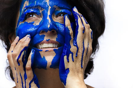 smiling woman with blue paint on her face