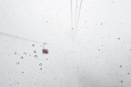 cable car through clear glass with water droplets