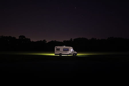 white RV on the road during night time