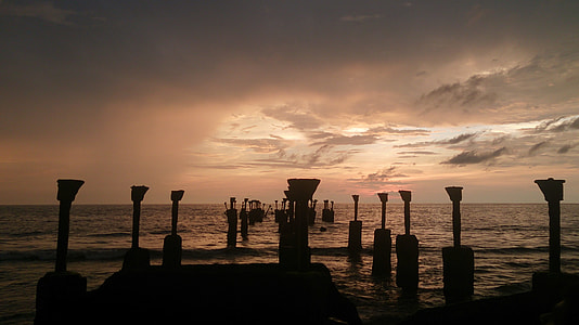 silhouette photo of posts on water