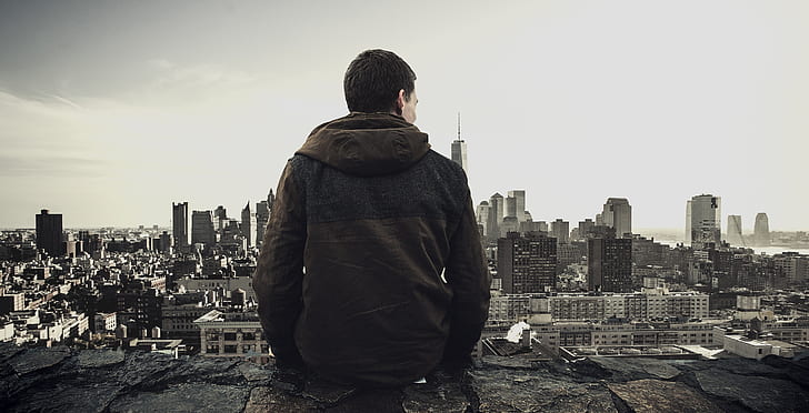 person sitting at the edge overlooking the city