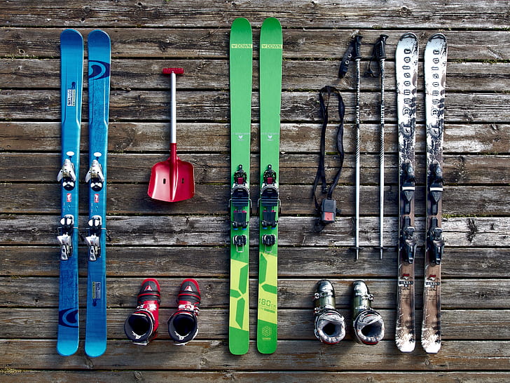 three pairs of snow skis with bindings and ski poles