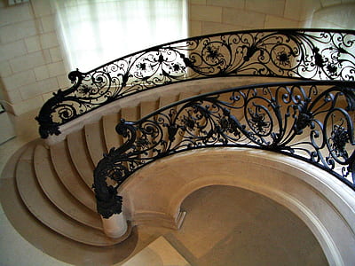 brown concrete stair with black metal handrail