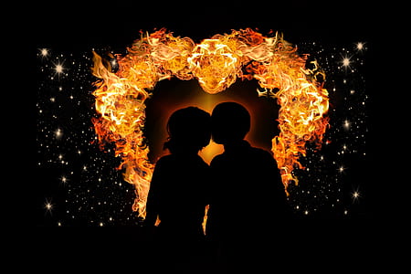 silhouette of two person with flame as back drop