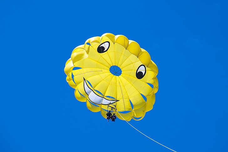 two person using yellow parachute during daytime