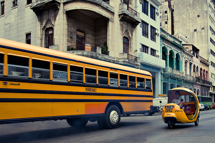 Retro street photo of a public bus and coco taxi, shot taken in Havana, Cuba
