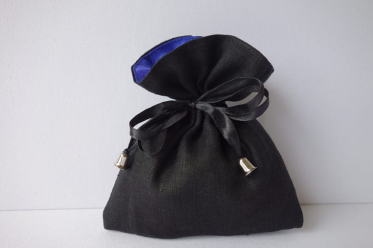 black drawstring purse on white surface