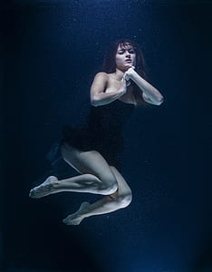 woman wearing black strapless dress underwater
