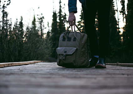 person carrying gray bag