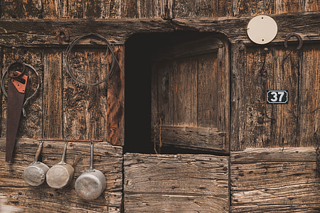 brown wooden door near three silver cooking pots