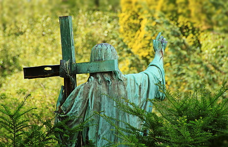 Christ carrying cross surrounded with grass statuette