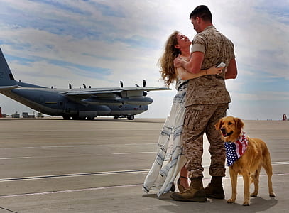 golden retriever standing next to woman and man hugging