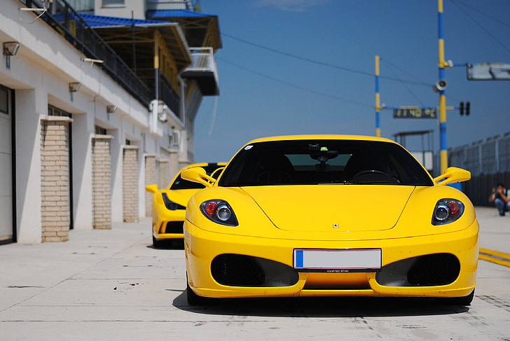 yellow Ferrari sports car on road during daytime