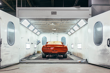 orange car inside a well-lighted open garage