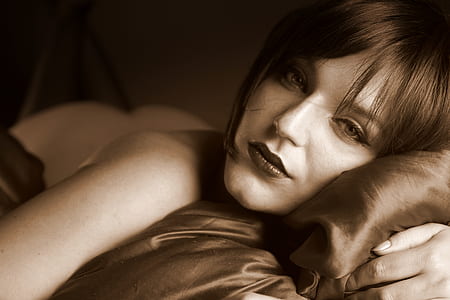woman lying on bed sepia photo