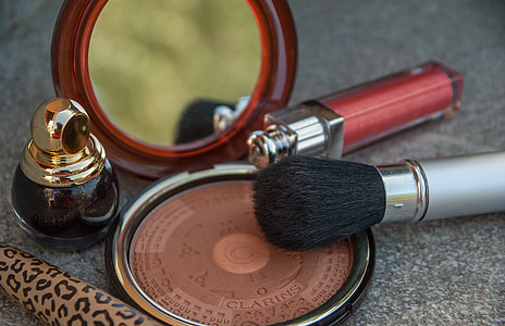 Clarins brown contour, red lipstick, and gold glass bottle