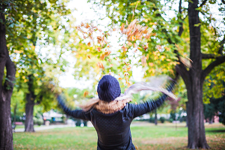 Girl Throwing Autumn Leaves in The Air