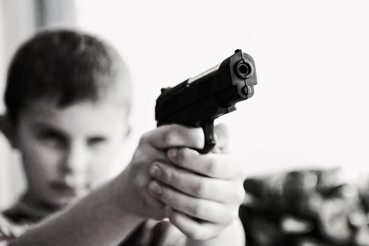 boy holding black semi-automatic pistol