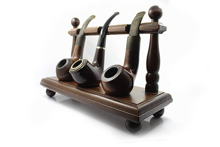 three brown wooden smoking pipe with rack