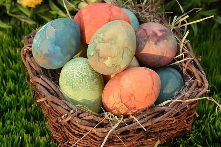 assorted-color Easter eggs on brown wicker basket