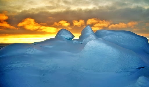 ground covered with snow during golden hour photo