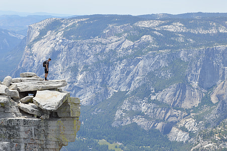 man standing on cliff during daytime