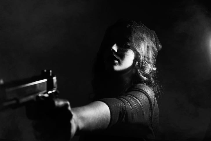 grayscale photo of person holding pistol