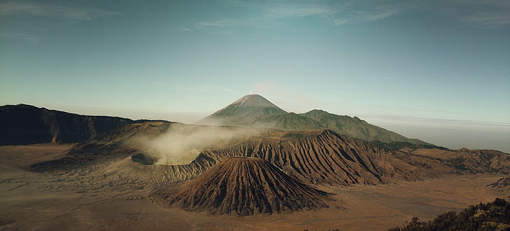 brown volcano under cloudy sky during daytime