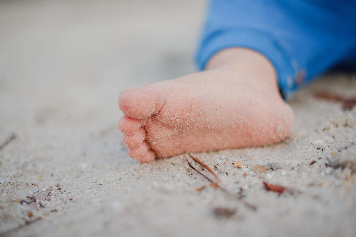 baby's right feet on sand