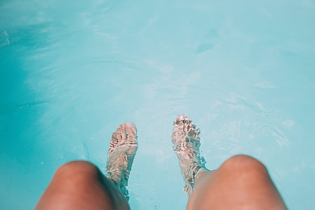 person's feet in water