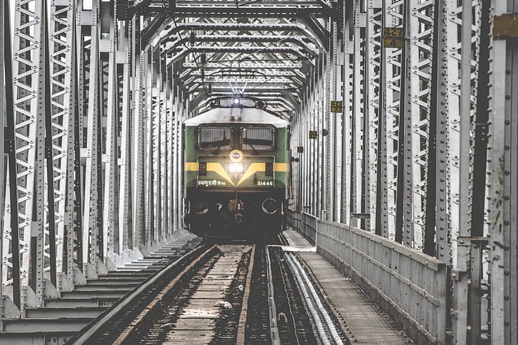 green and gray train near gray metal post at daytime