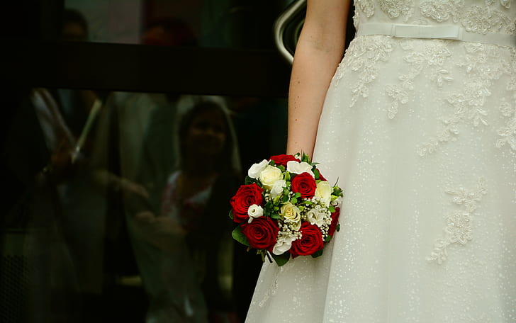 woman wearing white wedding dress holding rose flower bouquet