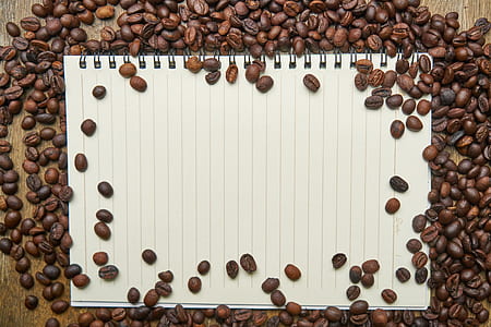 bunch of coffee beans and white notebook