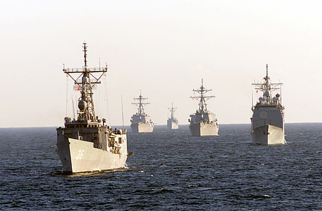 five brown fighting ships on sea