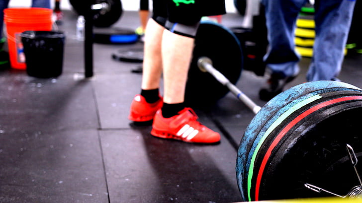 person standing in front of barbell