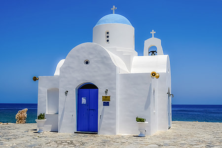 white and blue painted church near body of water