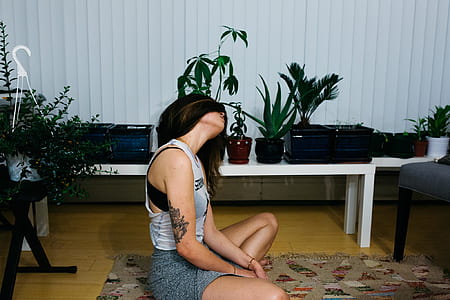 woman sitting on brown area rug