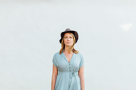 woman wearing teal half-button cap sleeve dress and black hat