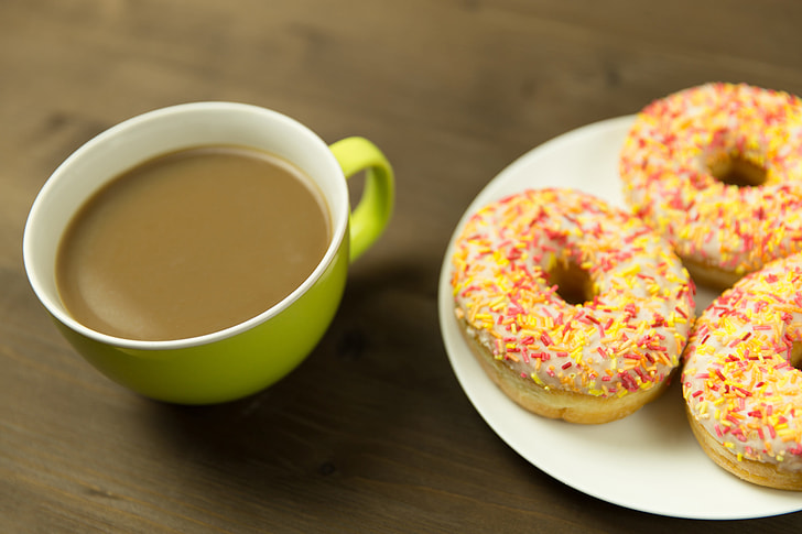 Coffee cup and donuts on desk