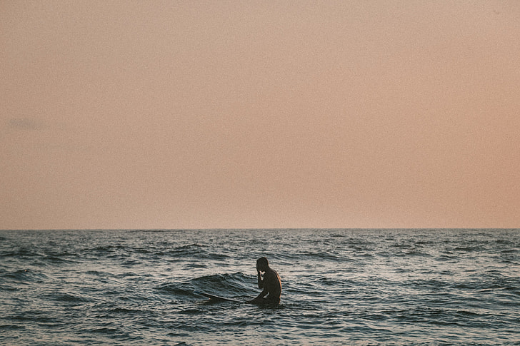 photography of surfer in the middle of the sea