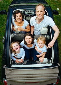 photo of family in convertible car during daytime