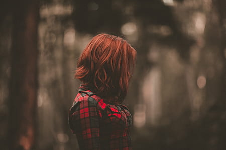 woman with short red hair wearing red and black plaid shirt
