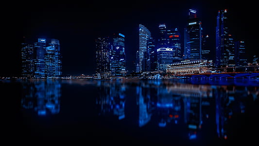 Illuminated Cityscape Against Blue Sky at Night