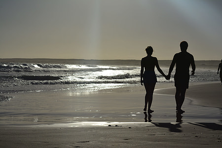 silhouette photography of man and woman near sea