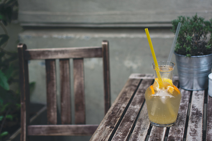 Orange lemonade at a wooden desk outside