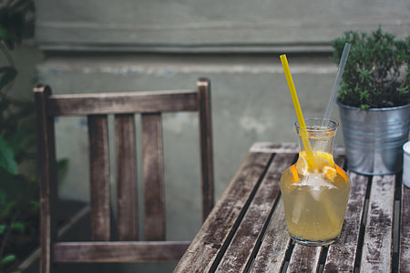 Orange lemonade at a wooden desk outside