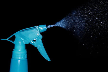 blue spray bottle with mist of water