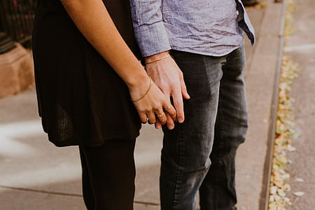 two person holding hands near road
