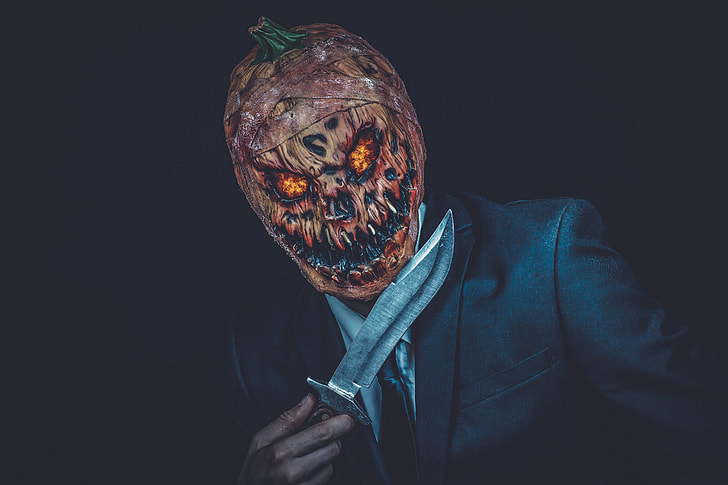 man wearing Jack-O-Lantern mask