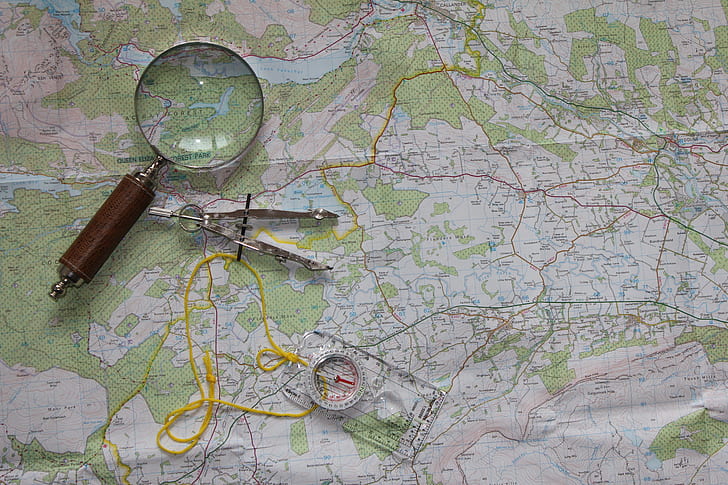 photo of magnifying glass and ruler on map